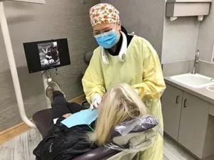 dentist examining female patient in chair, Invisalign Millbrae, CA