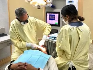 Dr. Warren and assistant doing dental work on patient, Millbrae, CA dental veneers